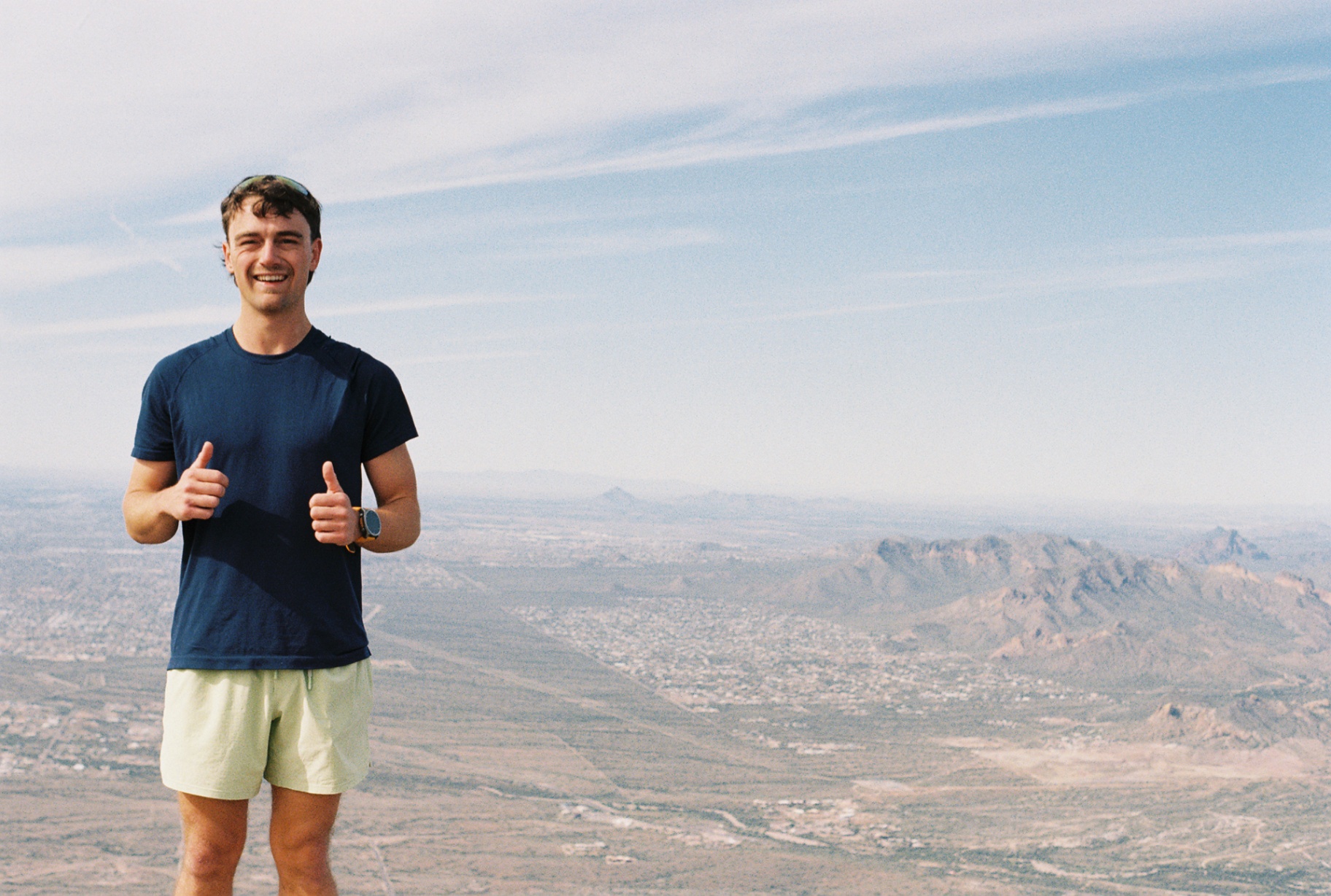 Levi at the summit with the Arizona desert stretched out behind him